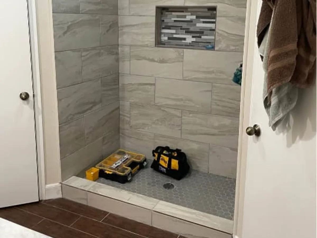 Walk in shower finished in large format gray tile