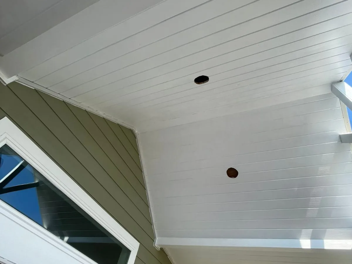 White tongue and groove porch ceiling with recessed can lights