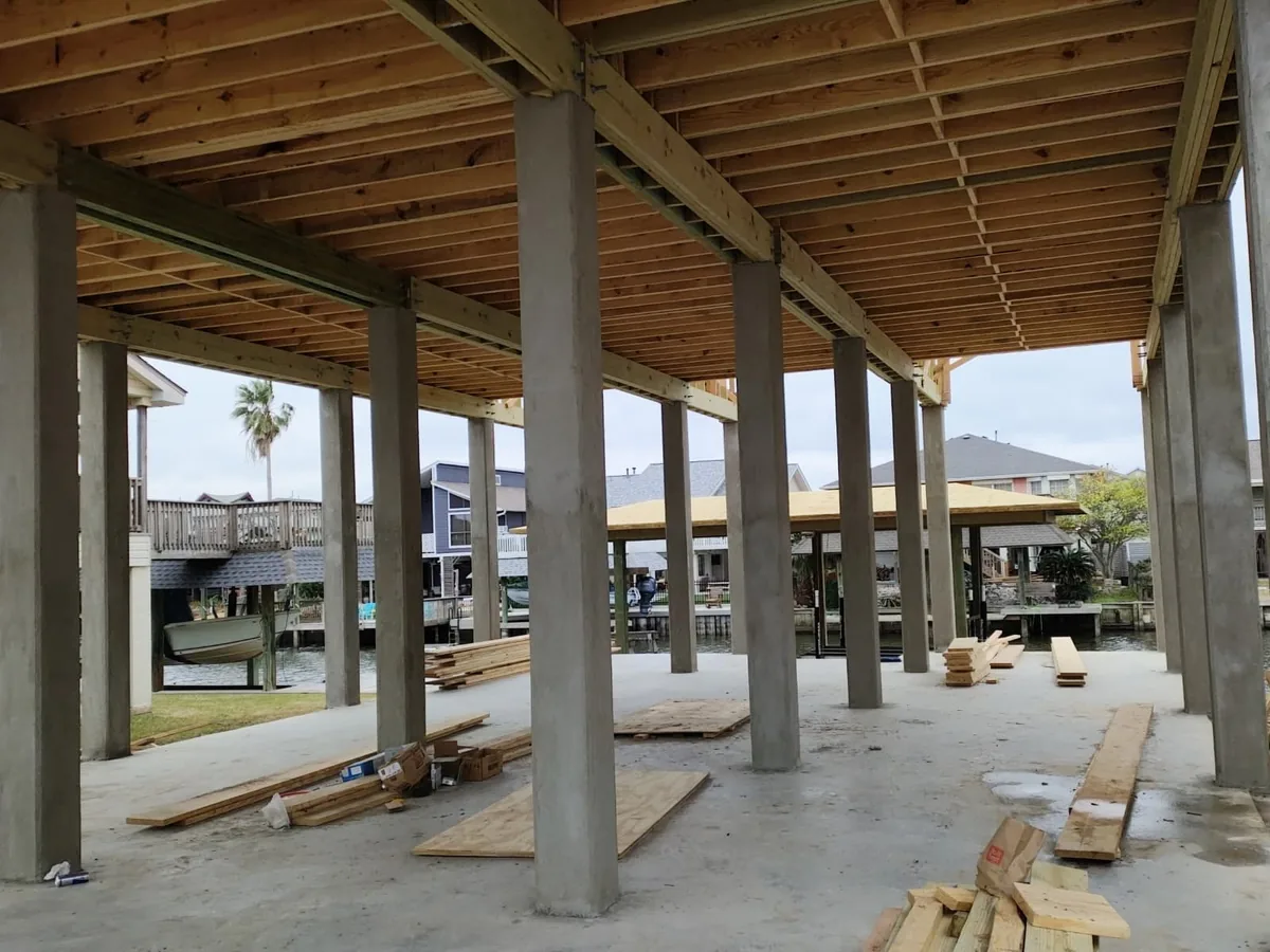 Ground level of an elevated home with concrete columns and a poured concrete slab