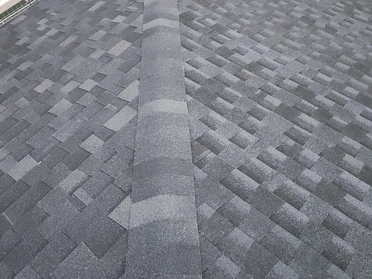 Gray architectural asphalt shingles with a ridge cap running along the roof peak